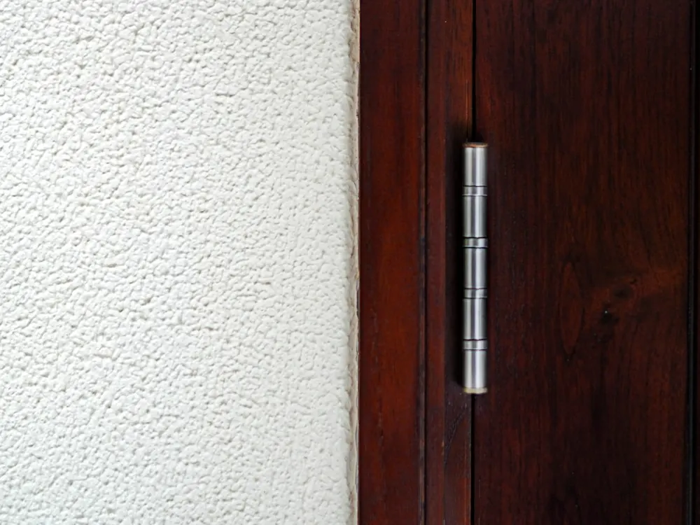 Gond métallique sur une porte en bois