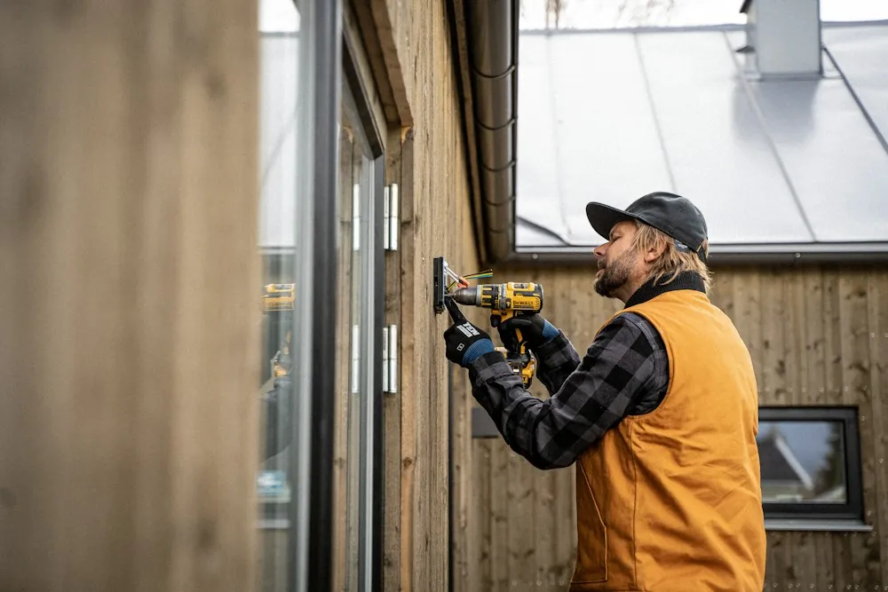 Technicien installant une porte avec une perceuse